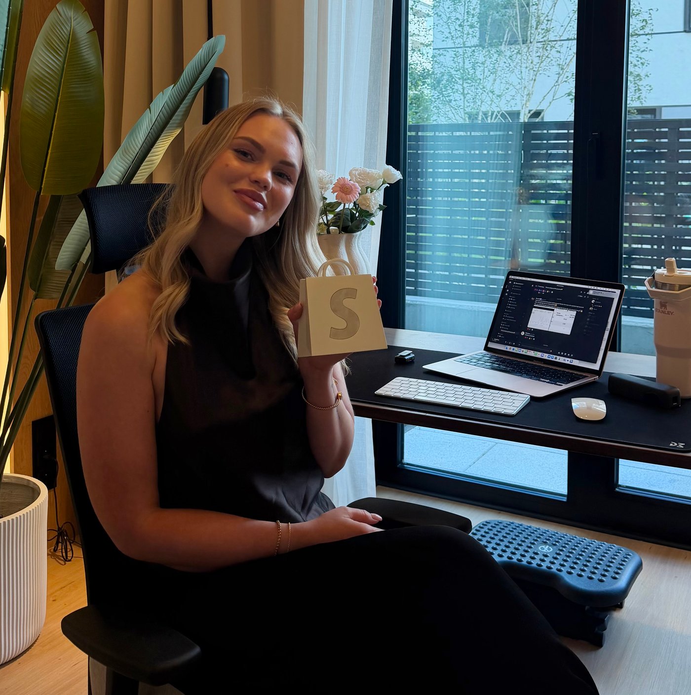 Isabelle vid sitt skrivbord med Shopify-utmärkelsen